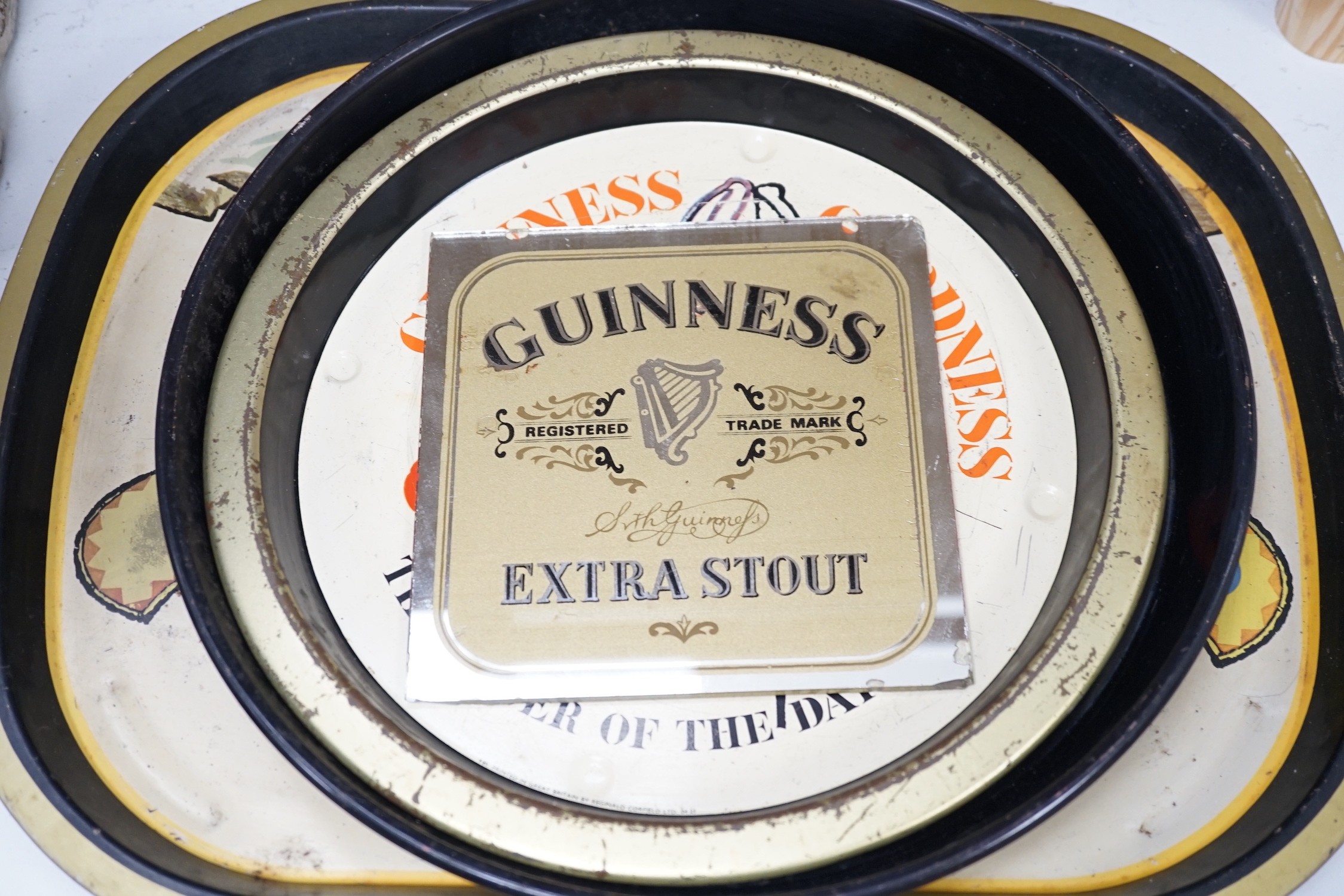 Five Guinness advertising signs, mirror, trays and a book - St. James’s Gate Brewery History and Guide